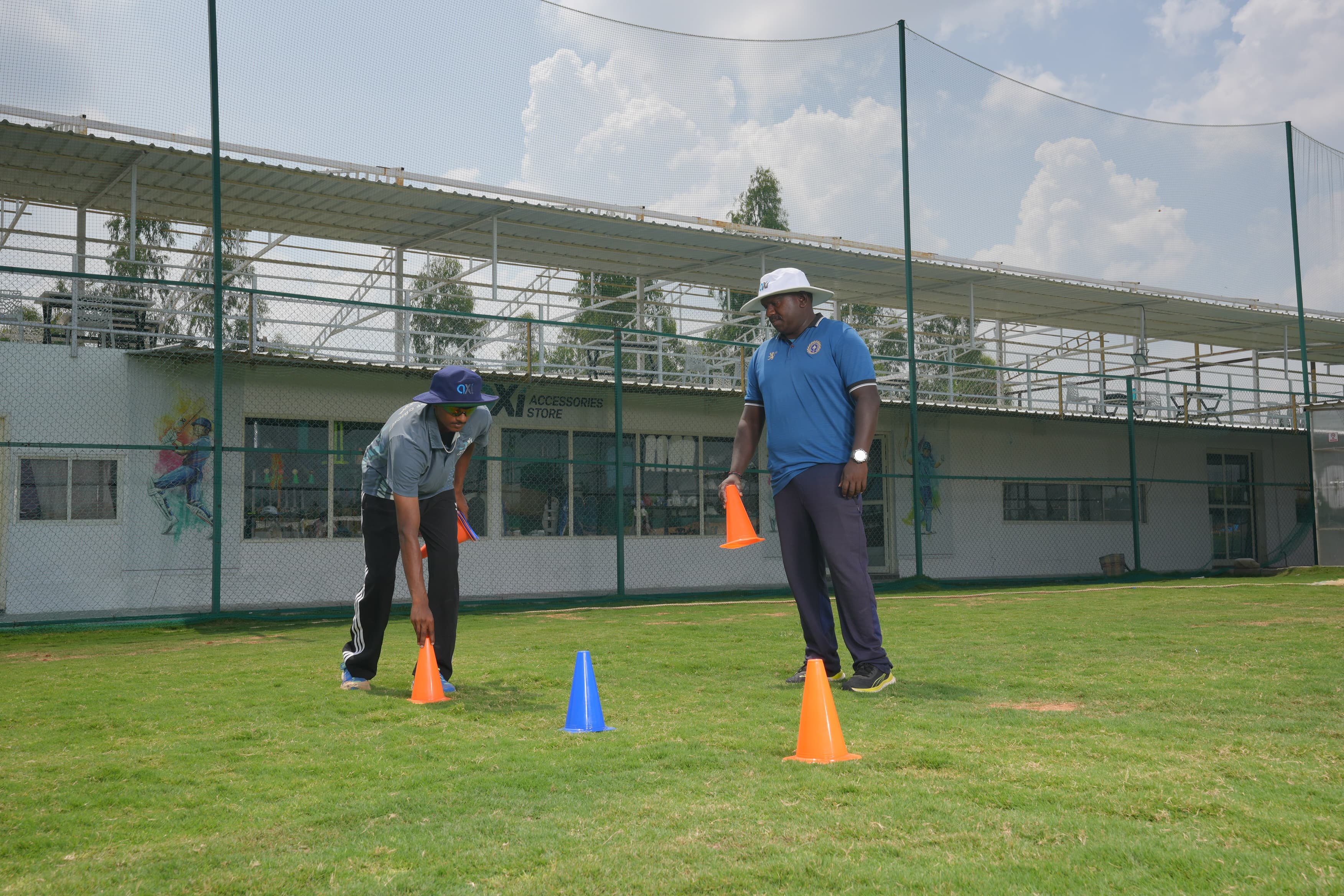 Cricket coach guiding a young player at Axi Academy, Bangalore