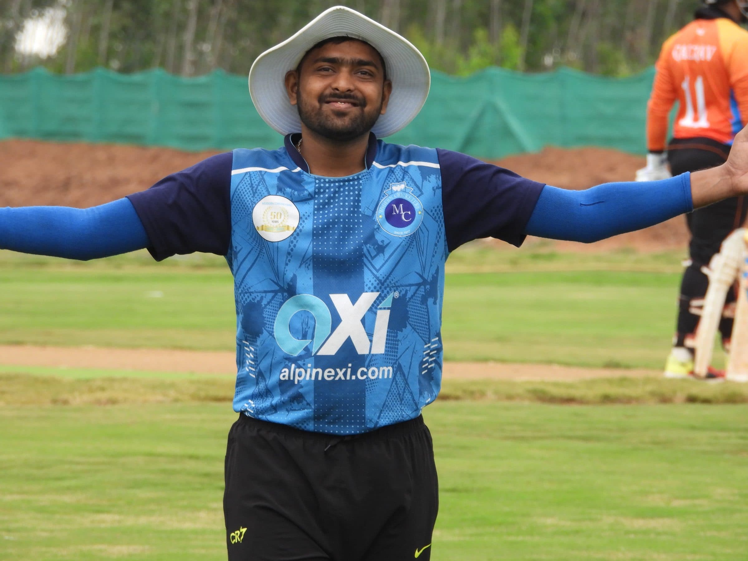 Axi Club player in club kit celebrating with arms outstretched during a match