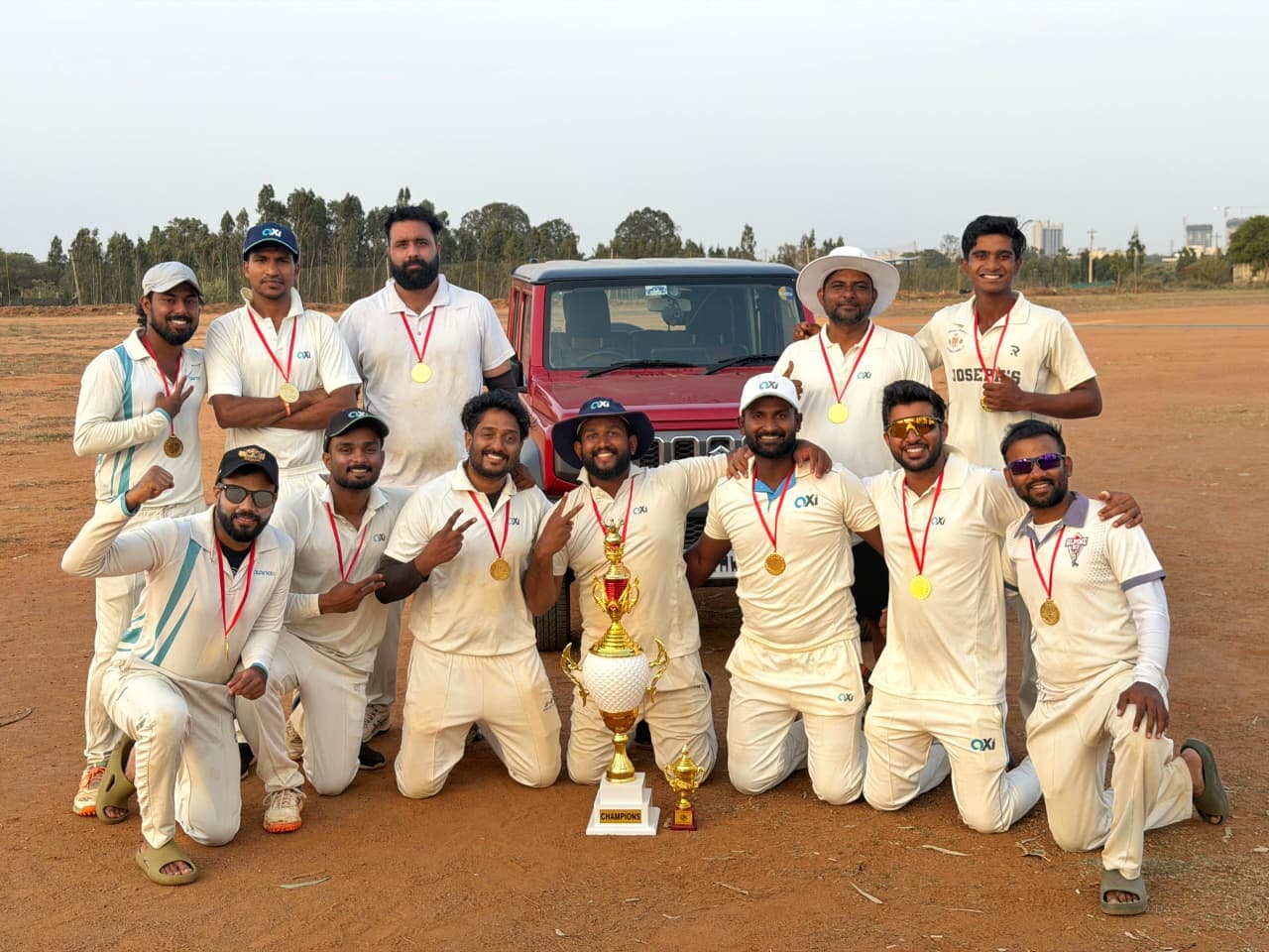 Axi Club squad in whites celebrating with the champions trophy and gold medals