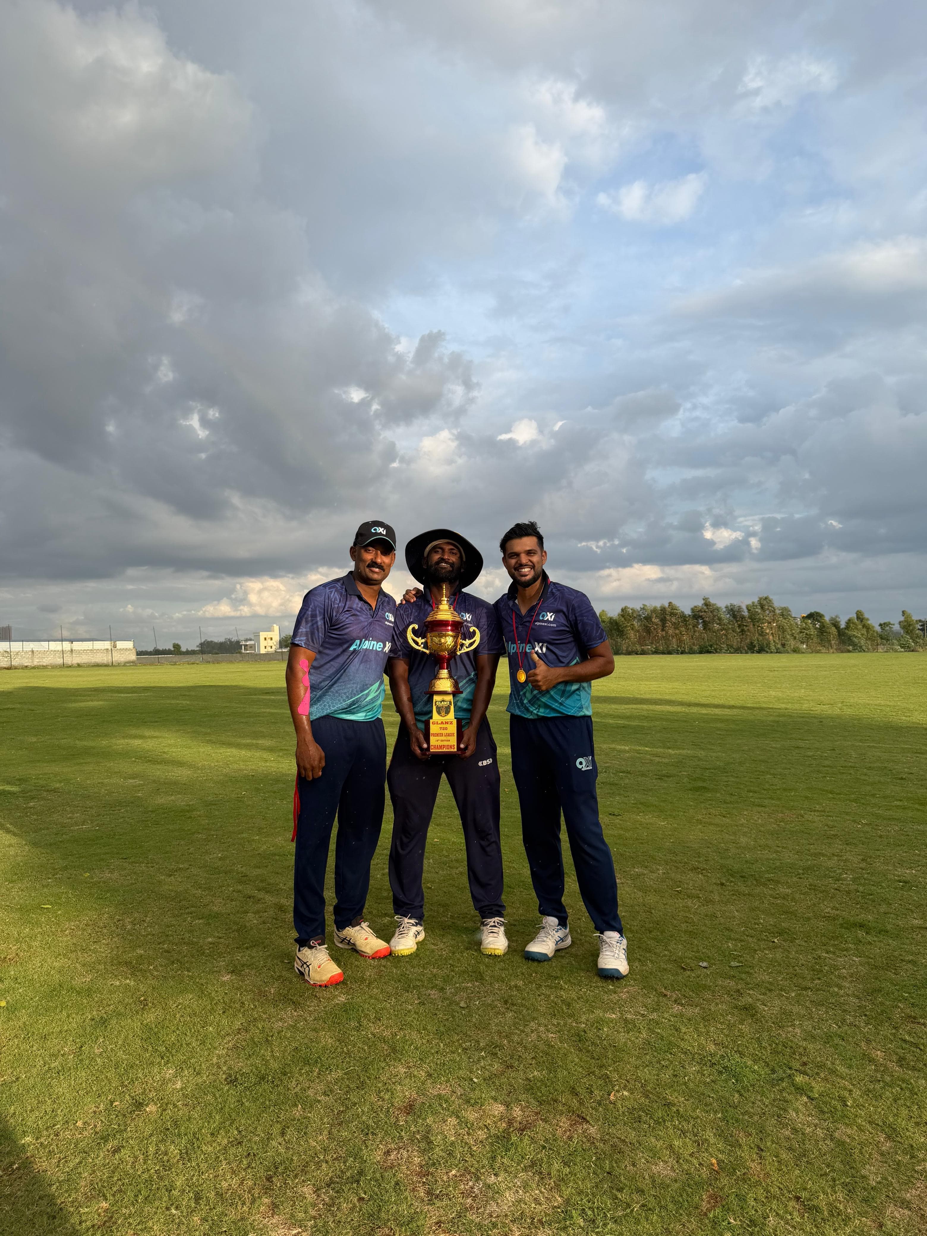 Axi Club players holding the Glanz T20 Premier League trophy on the outfield