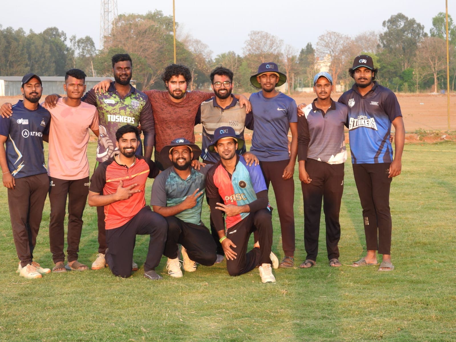 Axi Club squad group photo on the outfield in evening light after a match