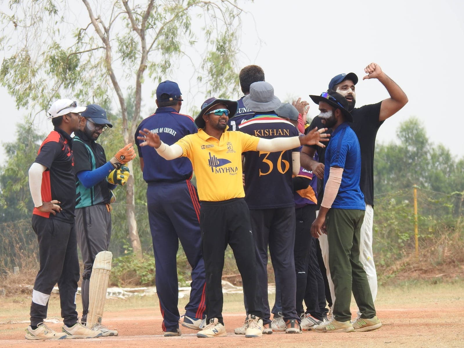 Axi Club players celebrating a breakthrough together on the outfield
