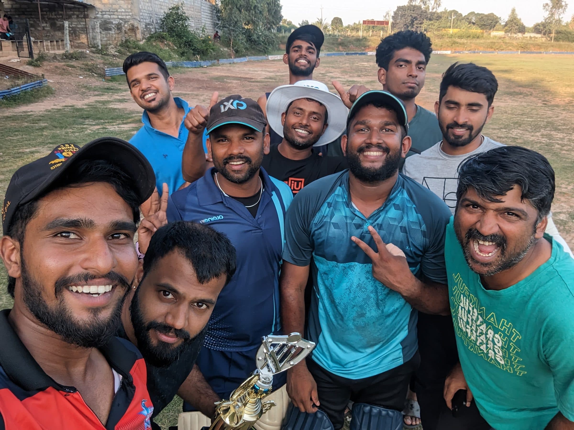 Axi Club squad crowding into a selfie around the trophy after winning a final